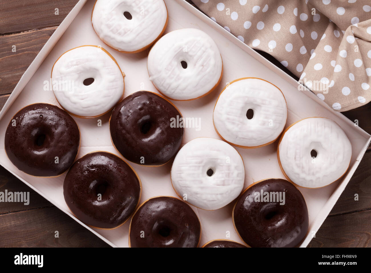 Krapfen in Box auf Holztisch. Ansicht von oben Stockfoto