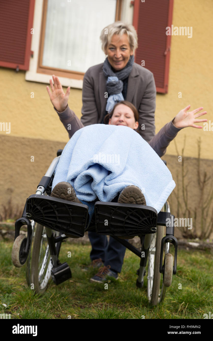 junge Frau im Rollstuhl, ist auf der Suche nach lustig, genießen das Leben trotz ihrer Behinderung Stockfoto