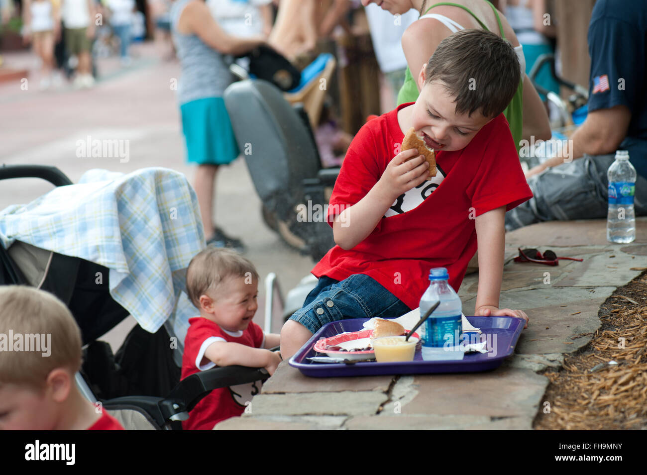 Junge Kinder Spaß Essen Müll im Vergnügungspark von Disney World in Florida uns zu Beginn des Sommers. Stockfoto