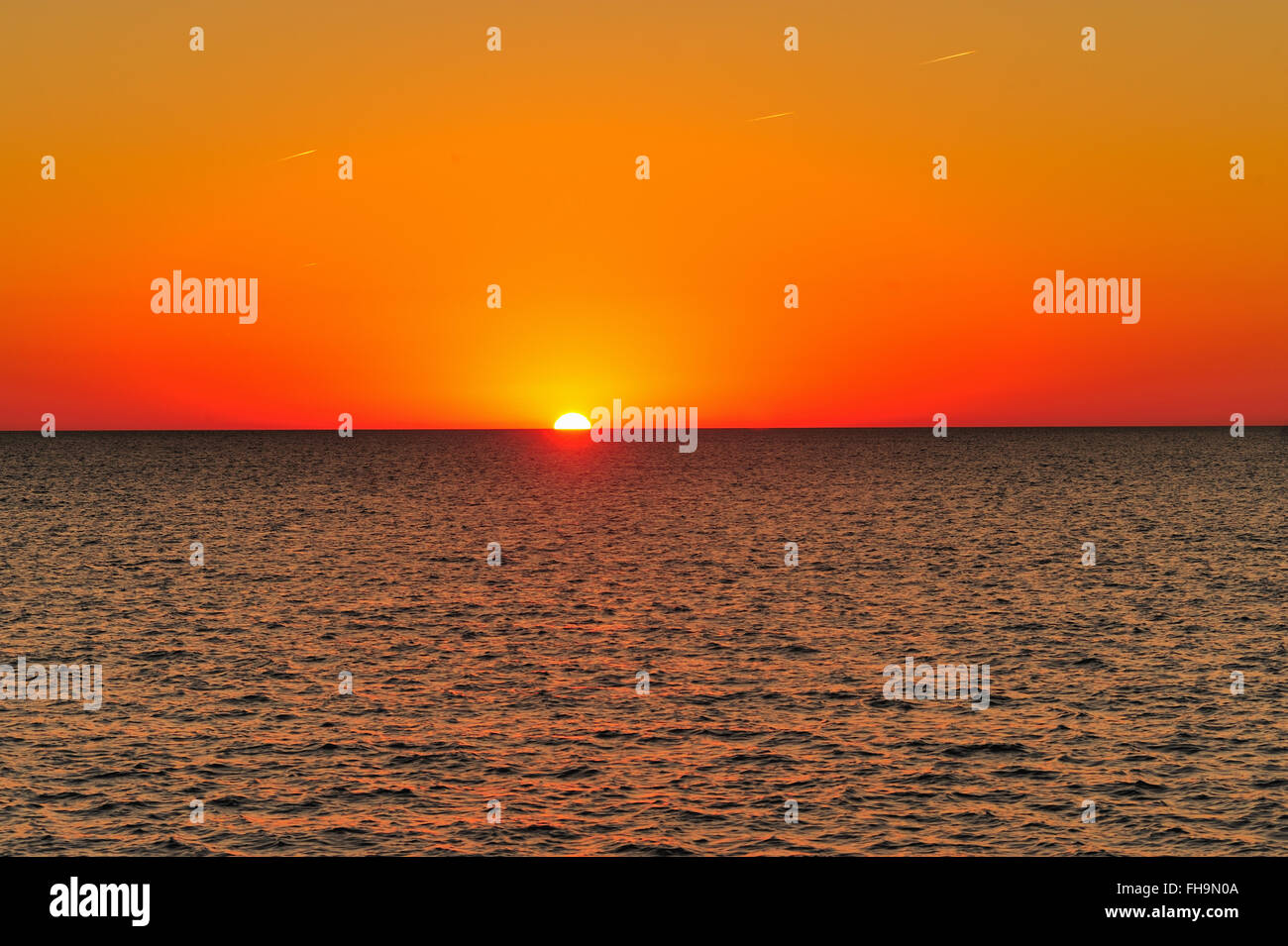 Chicago, Illinois, USA. Die Sonne den Horizont bei Sonnenaufgang über dem Lake Michigan wie aus dem Chicago Montrose Hafen gesehen. Stockfoto