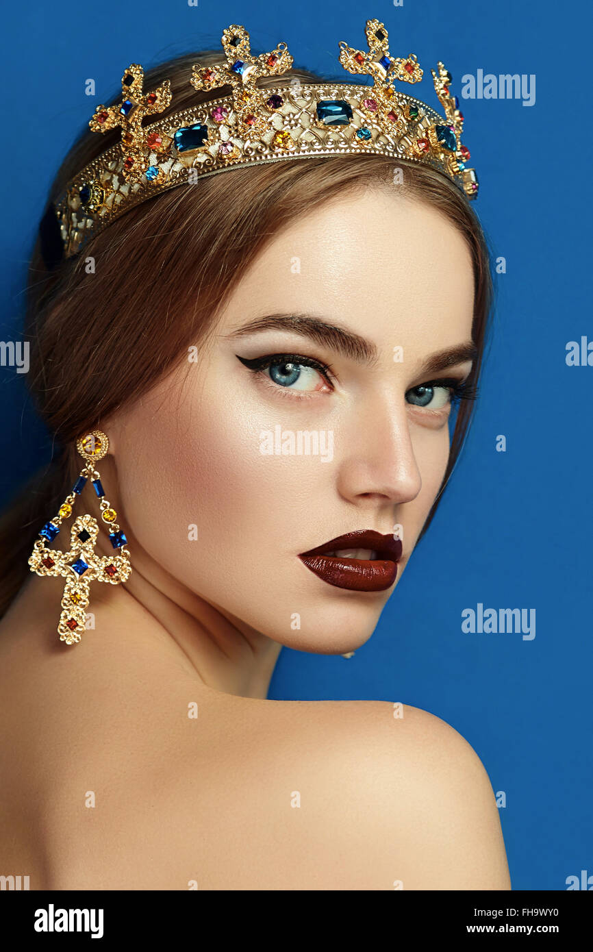 Mädchen mit einer goldenen Krone und goldenen Ohrringen. Stockfoto