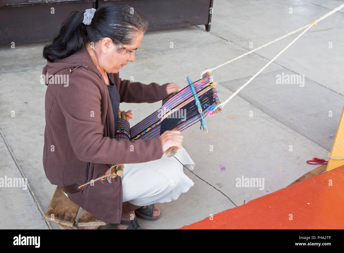 Santo Tomás Jalietza, Oaxaca, Mexiko - eine Frau arbeitet auf einem Rückengurt Webstuhl auf dem Weber-kooperative. Stockfoto