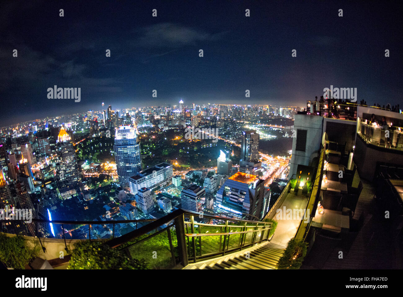 Bangkok Skyline bei Nacht vom Vertigo Restaurant Thailand // BANGKOK, Thailand – die glitzernde Skyline von Bangkok erstreckt sich unterhalb des Hotels vom Vertigo Restaurant auf dem Dach des Banyan Tree Hotels aus. Wolkenkratzer und Hochhäuser beleuchten die weitläufige thailändische Hauptstadt mit unzähligen Lichtern und schaffen ein atemberaubendes Stadtpanorama. Stockfoto