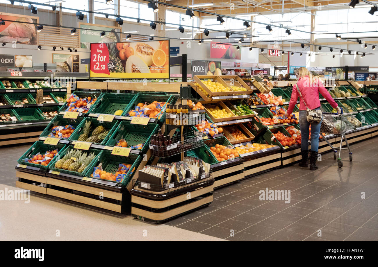 Supermarkt Gemüse GROSSBRITANNIEN; eine Frau kaufen Obst Obst und Gemüse Gang, Tesco Supermarkt store Innenraum, Suffolk UK Stockfoto