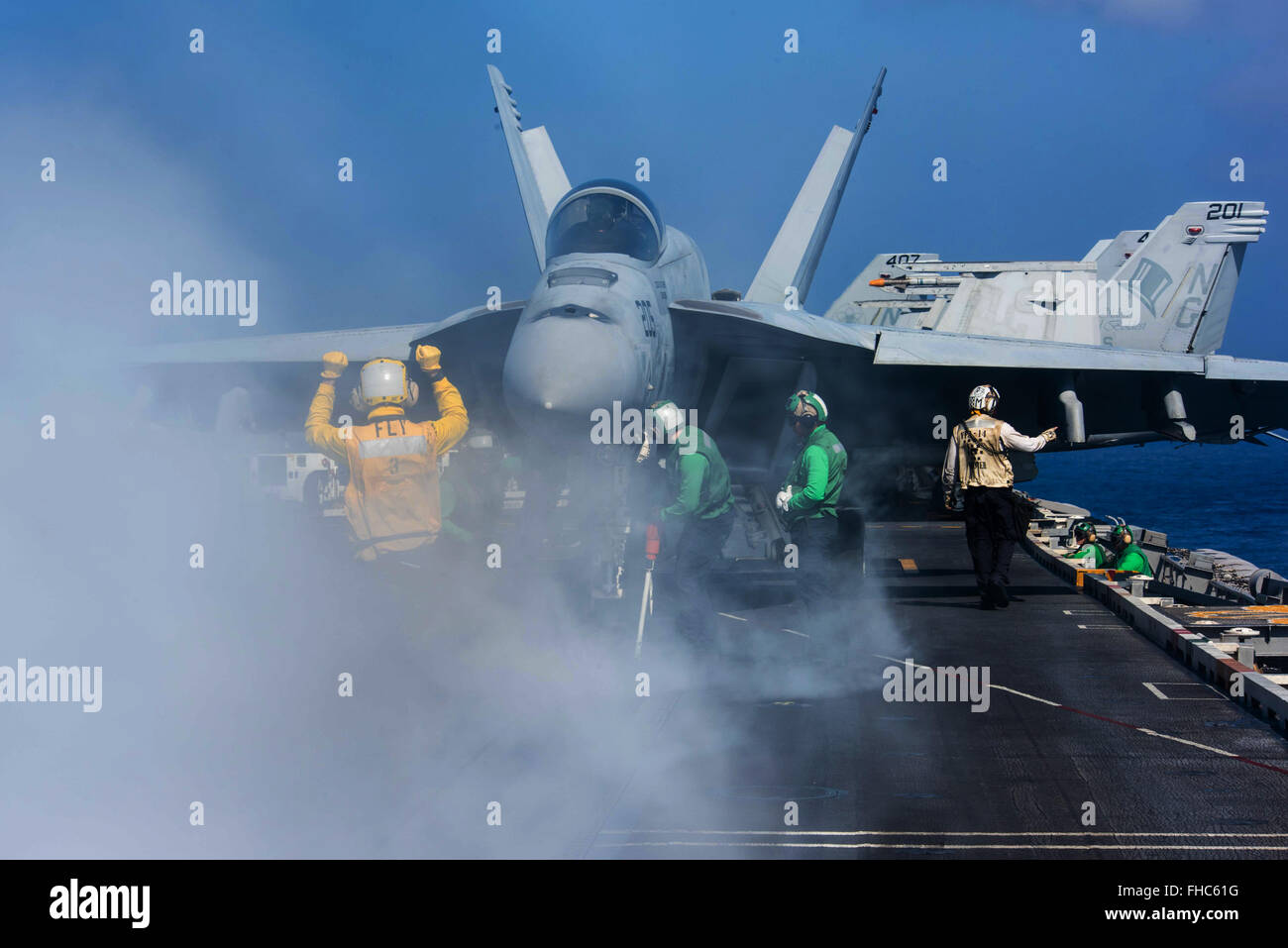 US Navy Matrosen direkt ein Kampfflugzeug F/A-18E Super Hornet auf dem Flugdeck an Bord der Nimitz-Klasse nuclear-powered Supercarrier USS John C. Stennis 23. Februar 2016 in der Philippinensee. Stockfoto