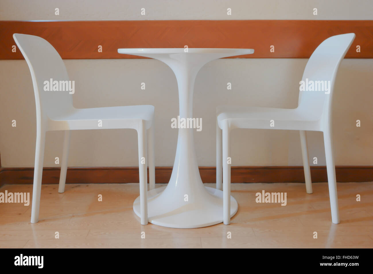 weißer Stuhl in einem leeren Raum mit Holzboden. Stockfoto