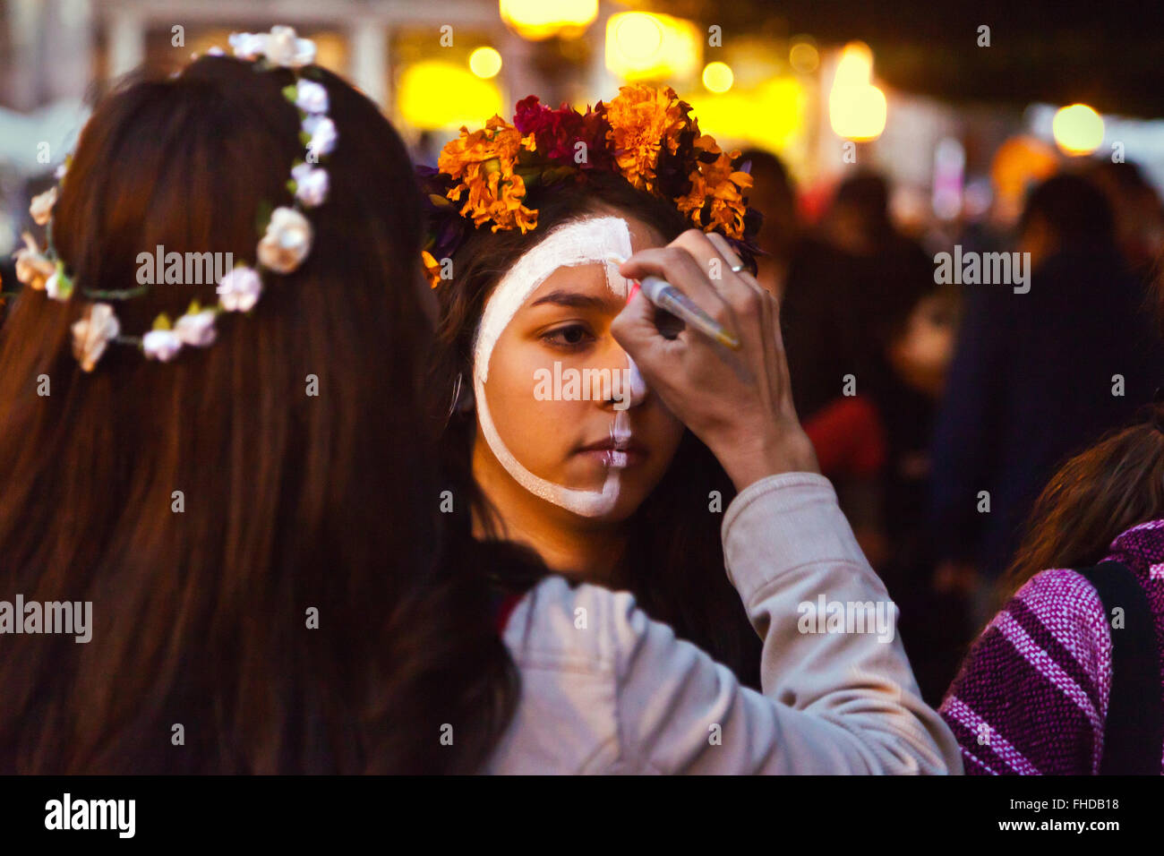 Gesichter sind wie Schädel gemalt, als Menschen sich in CATRINAS beim DAY OF THE DEAD - SAN MIGUEL DE ALLENDE, MEX verwandeln Stockfoto