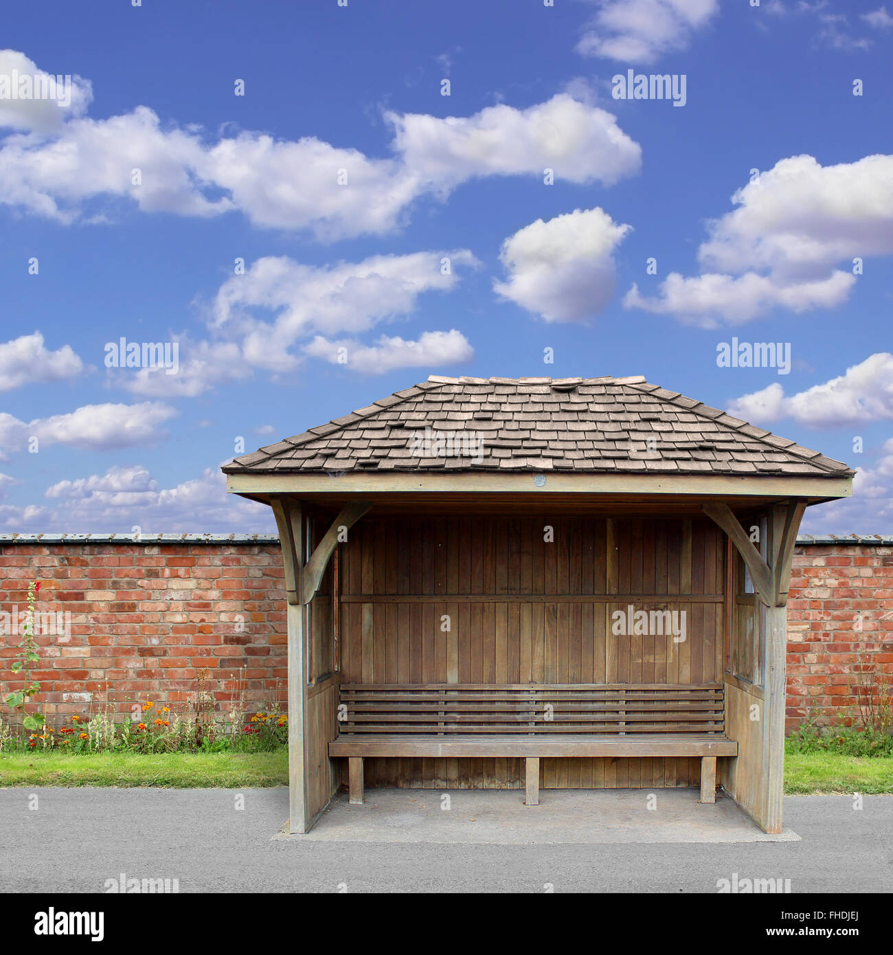 Eine alte hölzerne Wartehalle mit roten Backsteinmauer und blauer Himmel Stockfoto