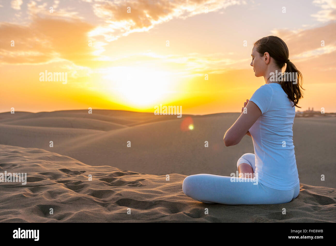 Frau praktizieren Yoga auf Sanddünen Stockfoto