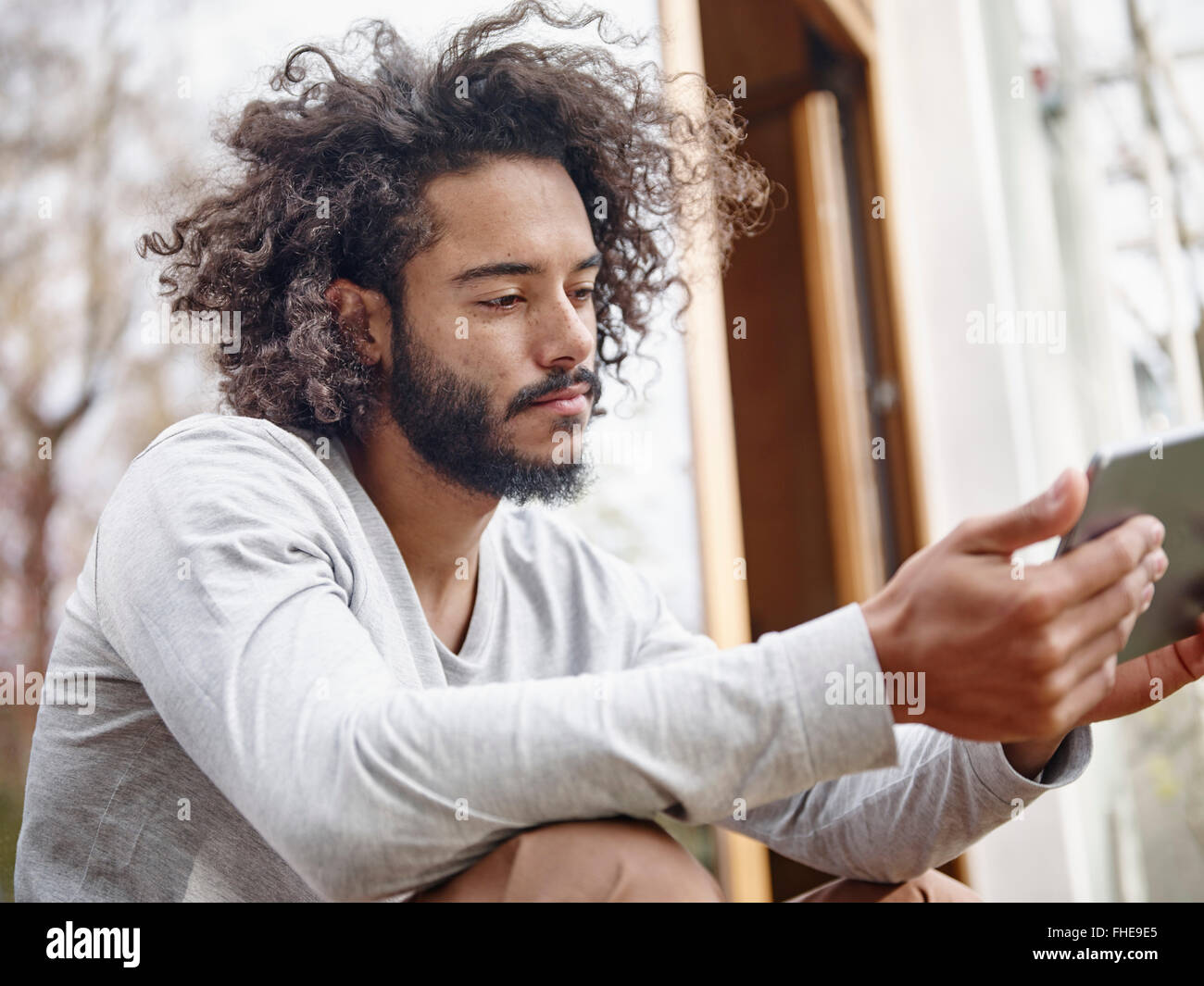 Junger Mann, Blick auf digitale Tablet im freien Stockfoto
