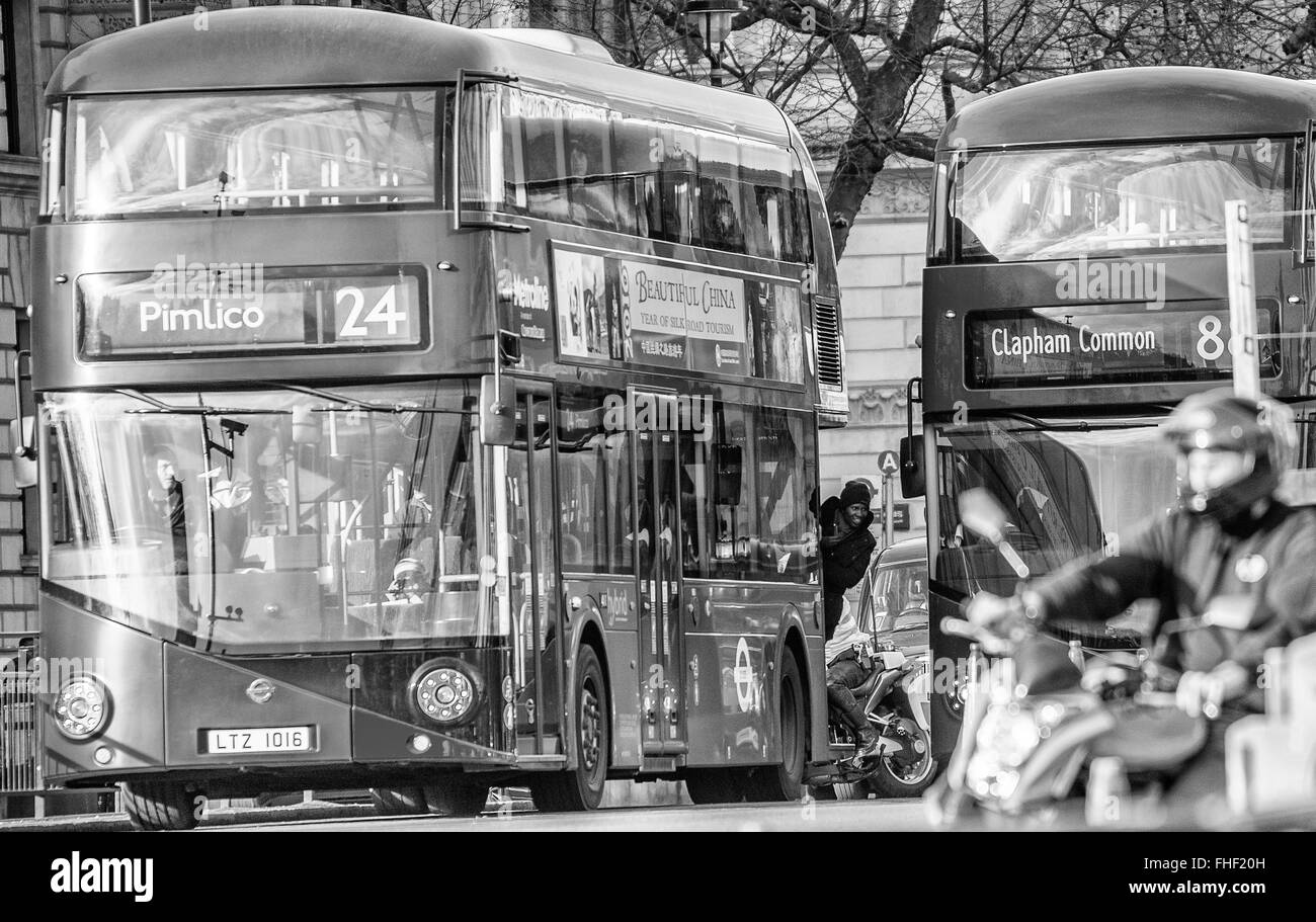Foto des Mannes aus der Rückseite des schiefen Nummer 24 London Bus nach Pimlico Whilsts Bus Nr. 8 an Clapham Common übergeben Stockfoto