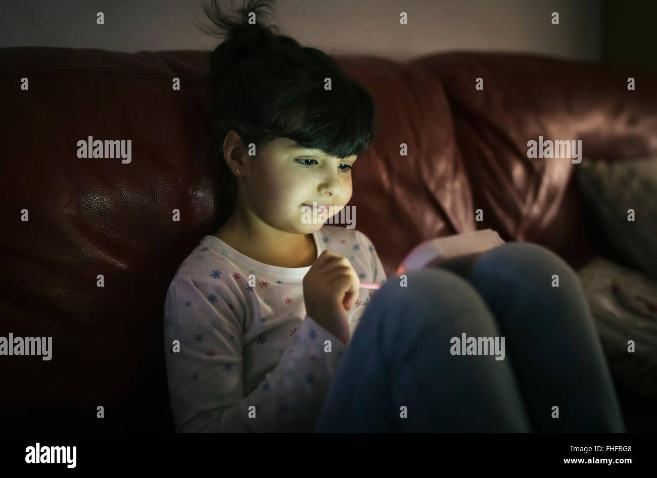 Porträt von kleinen Mädchen mit Spielkonsole zu Hause Stockfoto