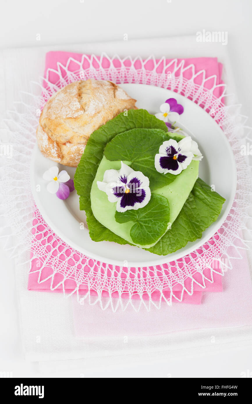 Platte mit Weizen Roll, Wasabi-Blätter, Wasabi Gouda und essbare Blumen Stockfoto