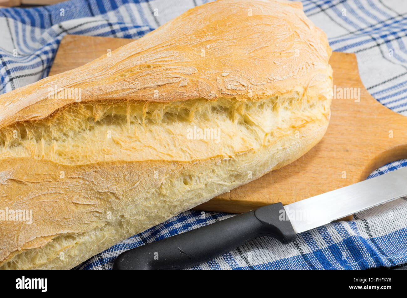 Hausgemachtes Brot und ein Messer auf dem Tisch Stockfoto