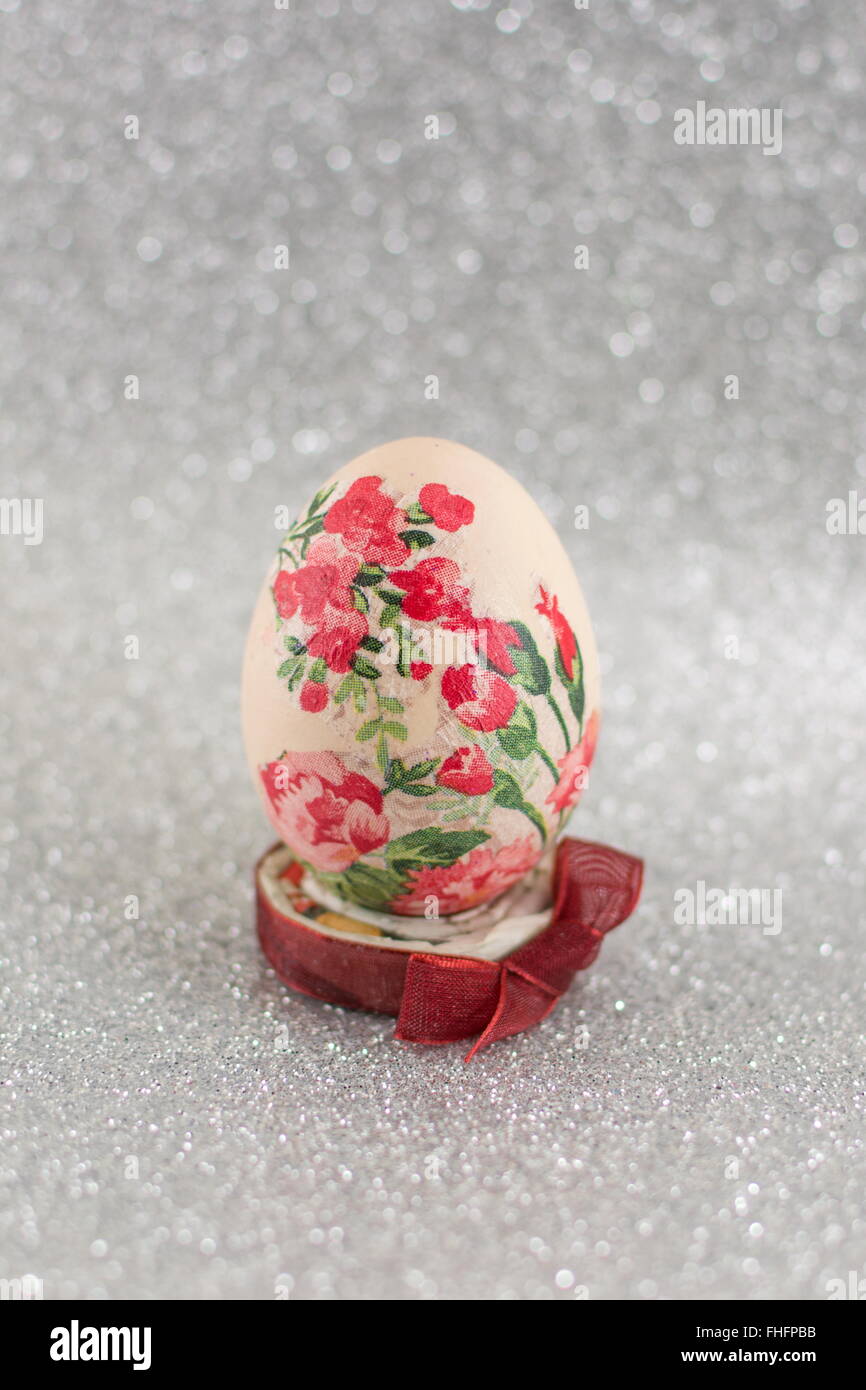 Bunte hausgemachte Serviettentechnik verziert Ostereier glänzend Silber Hintergrund Stockfoto