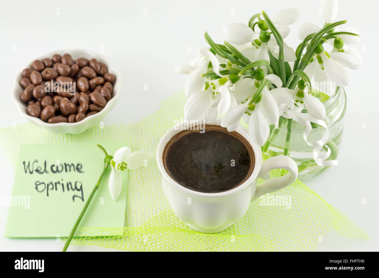 Frühling-Kaffeepause mit Bonbons und Schneeglöckchen in einem Glas Stockfoto