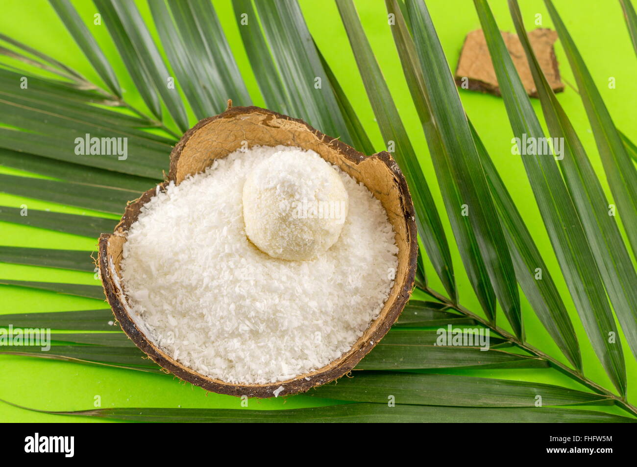 Kokos Pulver und Dessert in der Kokosnussschale auf grün Stockfoto