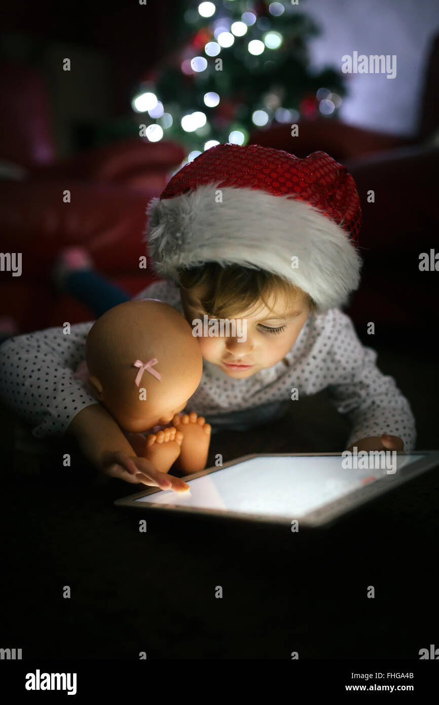 Porträt von kleinen Mädchen mit Weihnachten Mütze mit digital-Tablette zu Hause Stockfoto