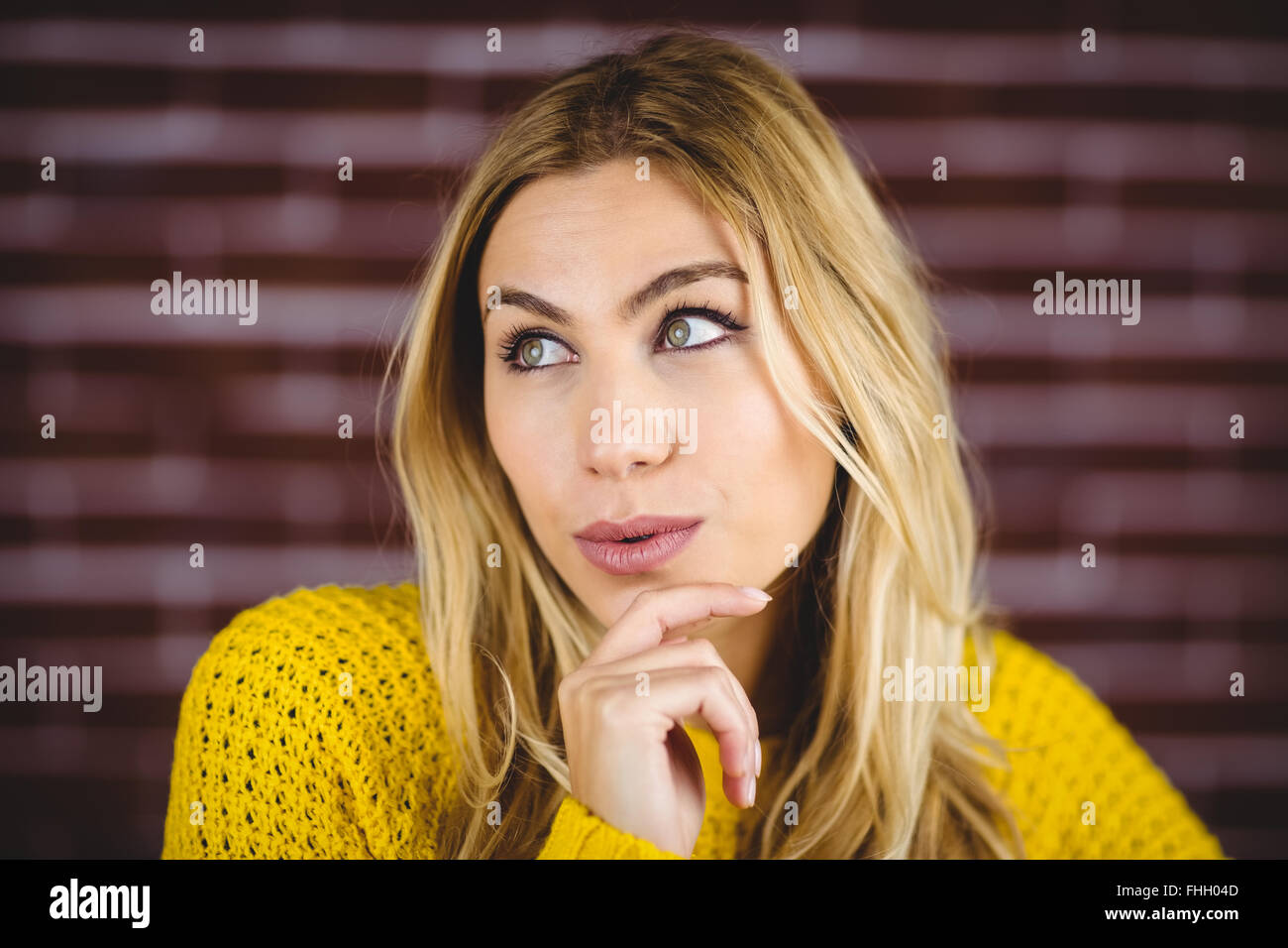 Schöne Frau Tagtraeume mit Hand am Kinn Stockfoto