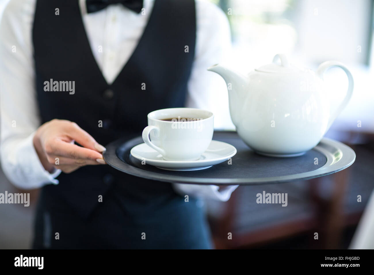 Kellnerin mit Tablett mit Tee Stockfoto