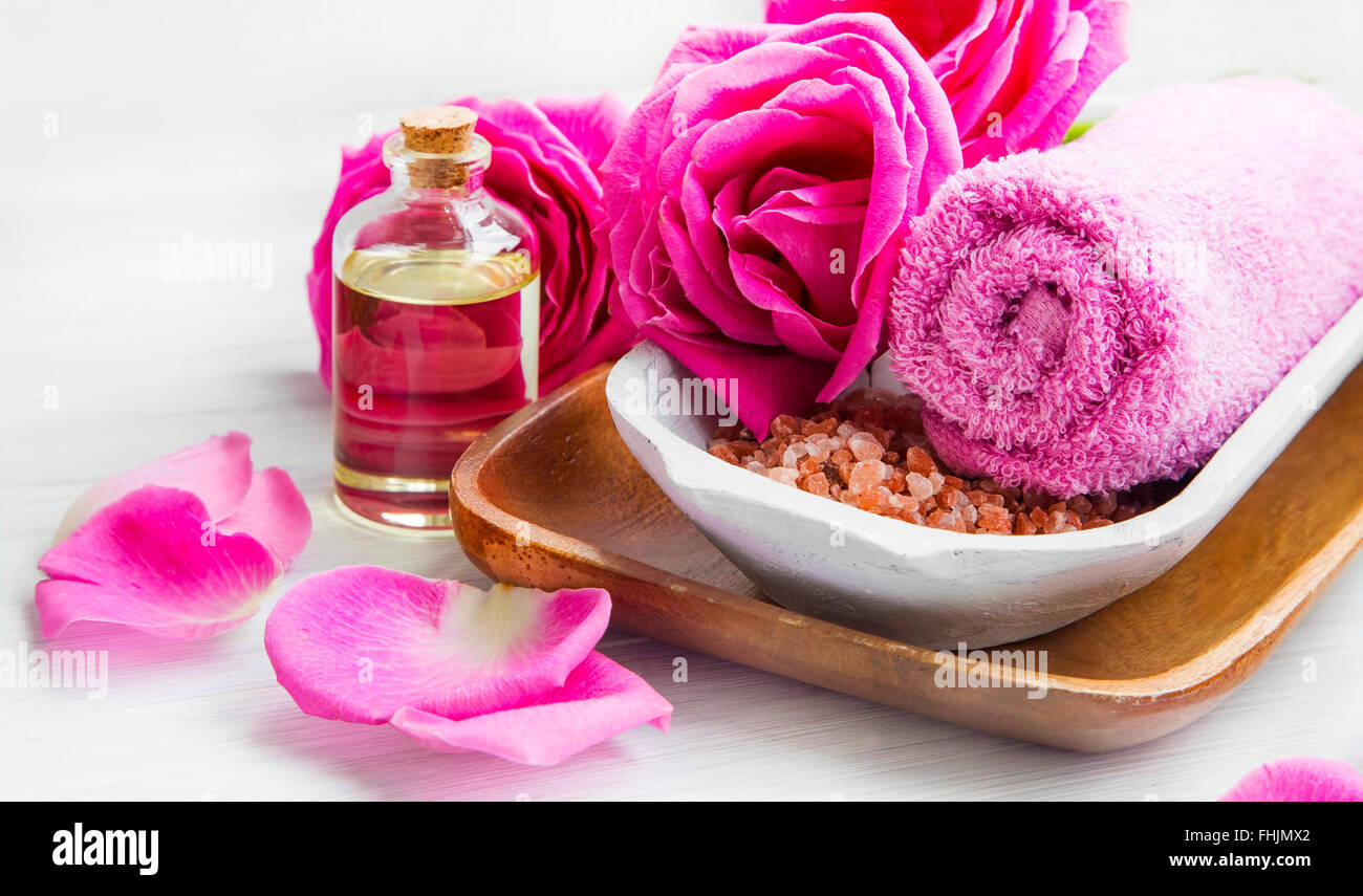 Spa-Ambiente mit rose rosa Blumen und Blütenblätter, Badesalz und Körper-Öl Stockfoto