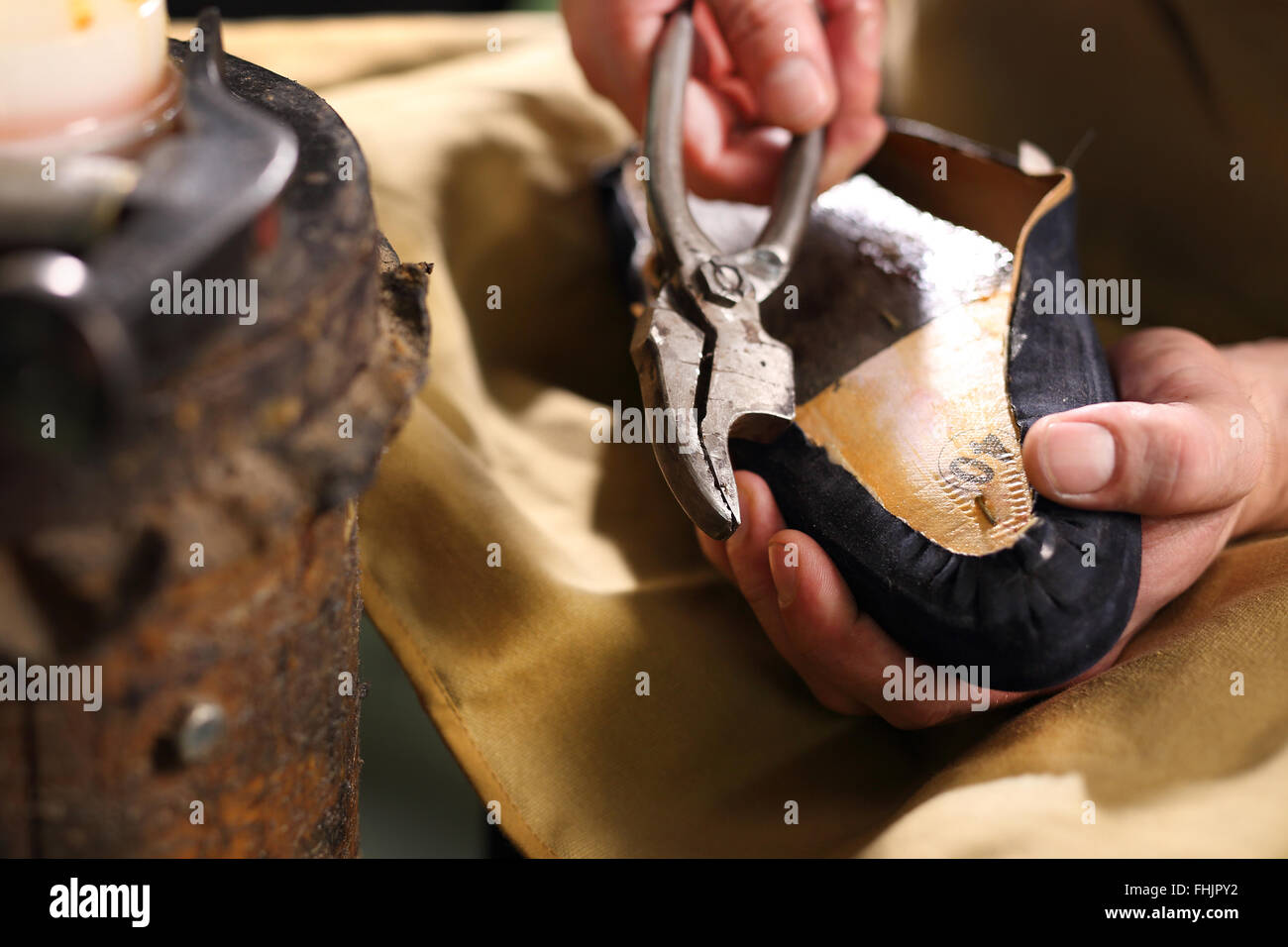 Nieten oben auf dem Huf. Schuhmacher führt Schuhe im Atelier Handwerk Stockfoto