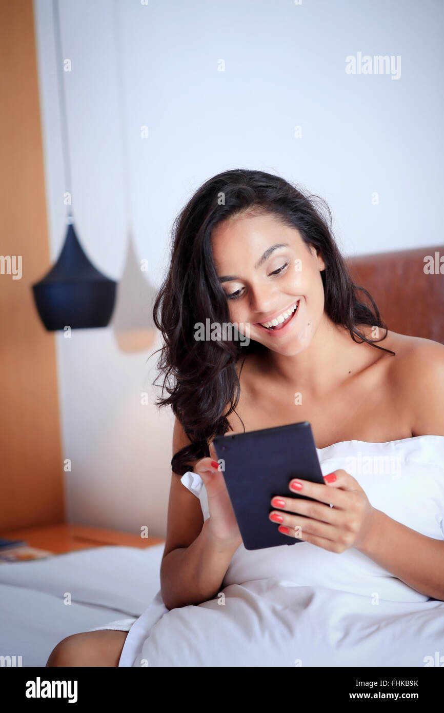 Hispanic Frau mit ihrem Handheld-Gerät in ihrem Hotelzimmer Stockfoto