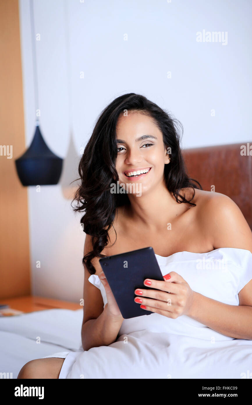 Hispanic Frau mit ihrem Handheld-Gerät in ihrem Hotelzimmer Stockfoto