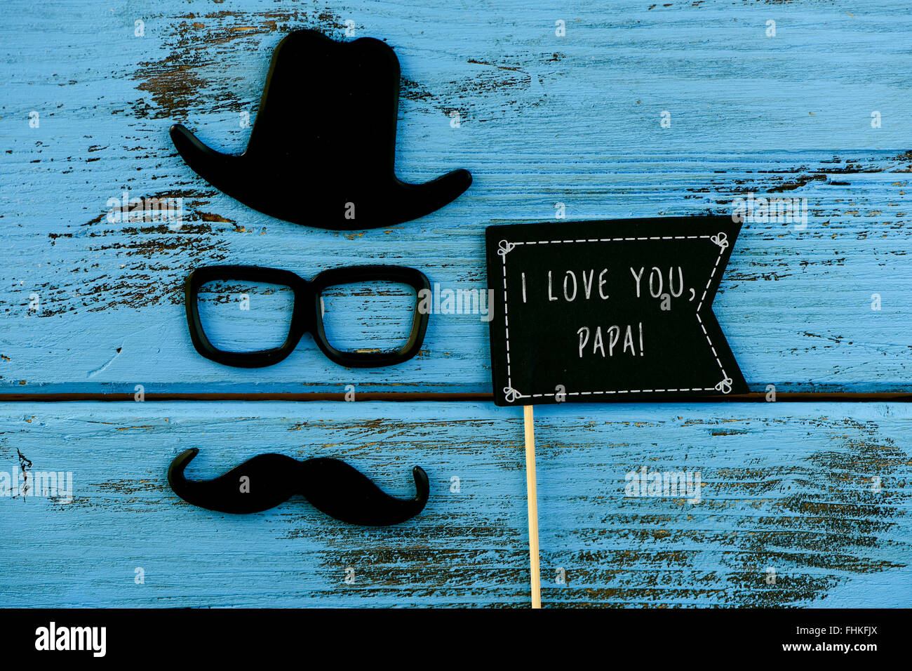 eine schwarze Flagge-förmigen Schild mit dem Text ich liebe dich, Papa, und einen Schnurrbart, eine Brille und einen Hut bildet das Gesicht des Stockfoto