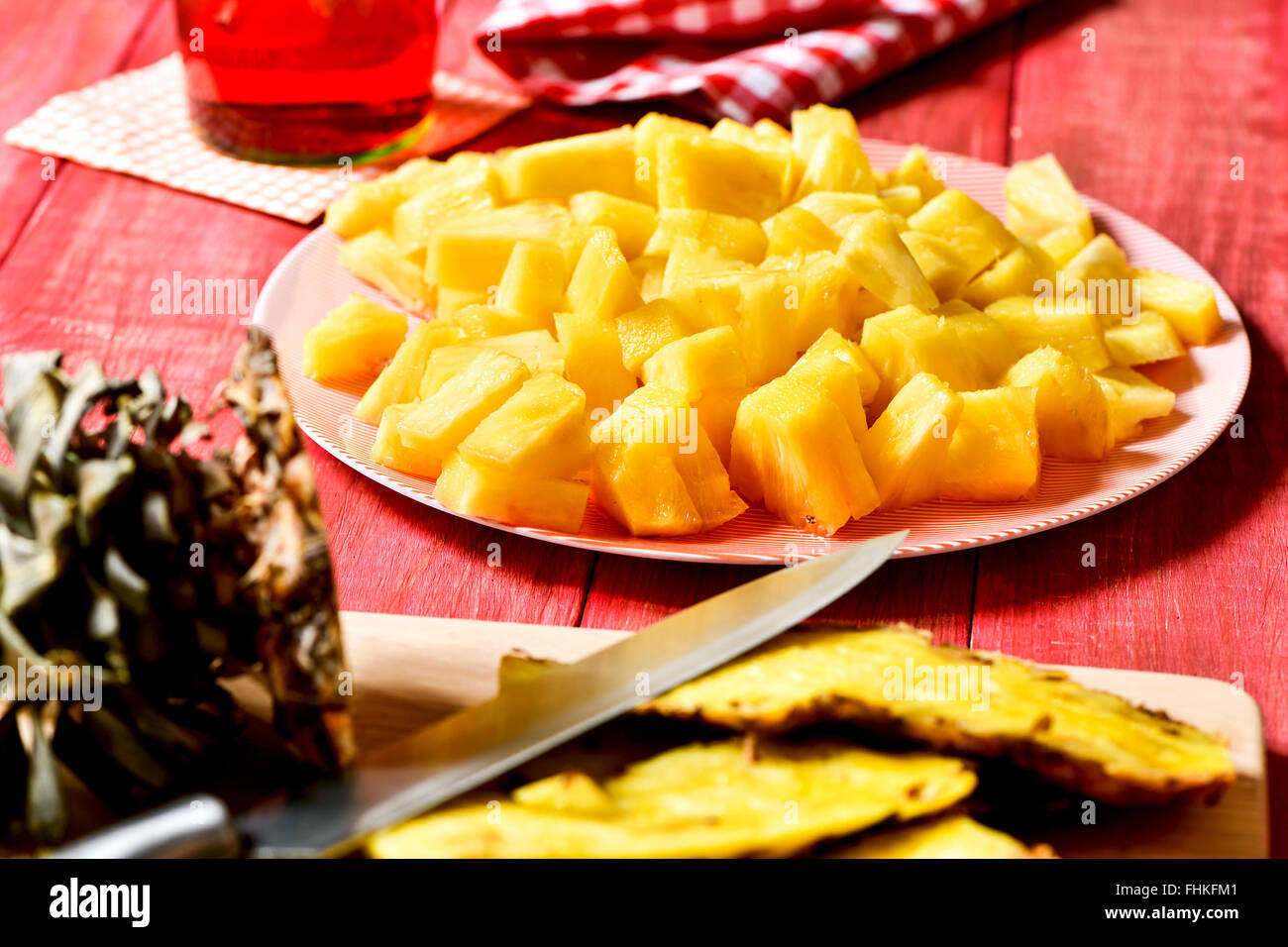 Nahaufnahme einer Platte mit frisch gewürfelte Ananas auf einem roten rustikalen Holztisch Stockfoto