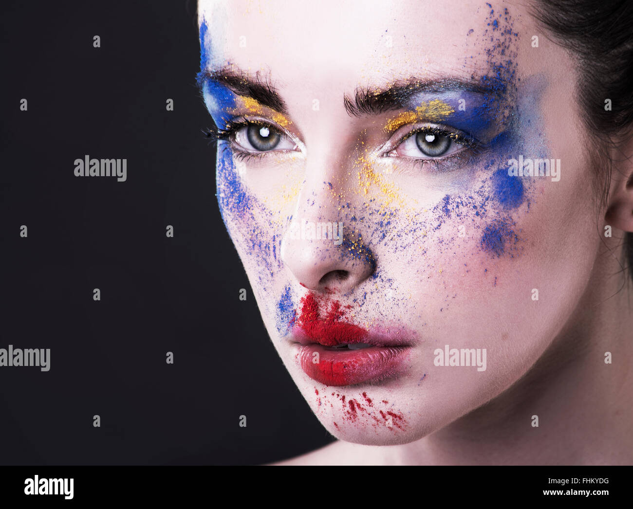 Hübsches Modell Blick nach links mit Puder Make-up im Gesicht. High-Fashion Beautyshot. Rot, blau, gelb Stockfoto