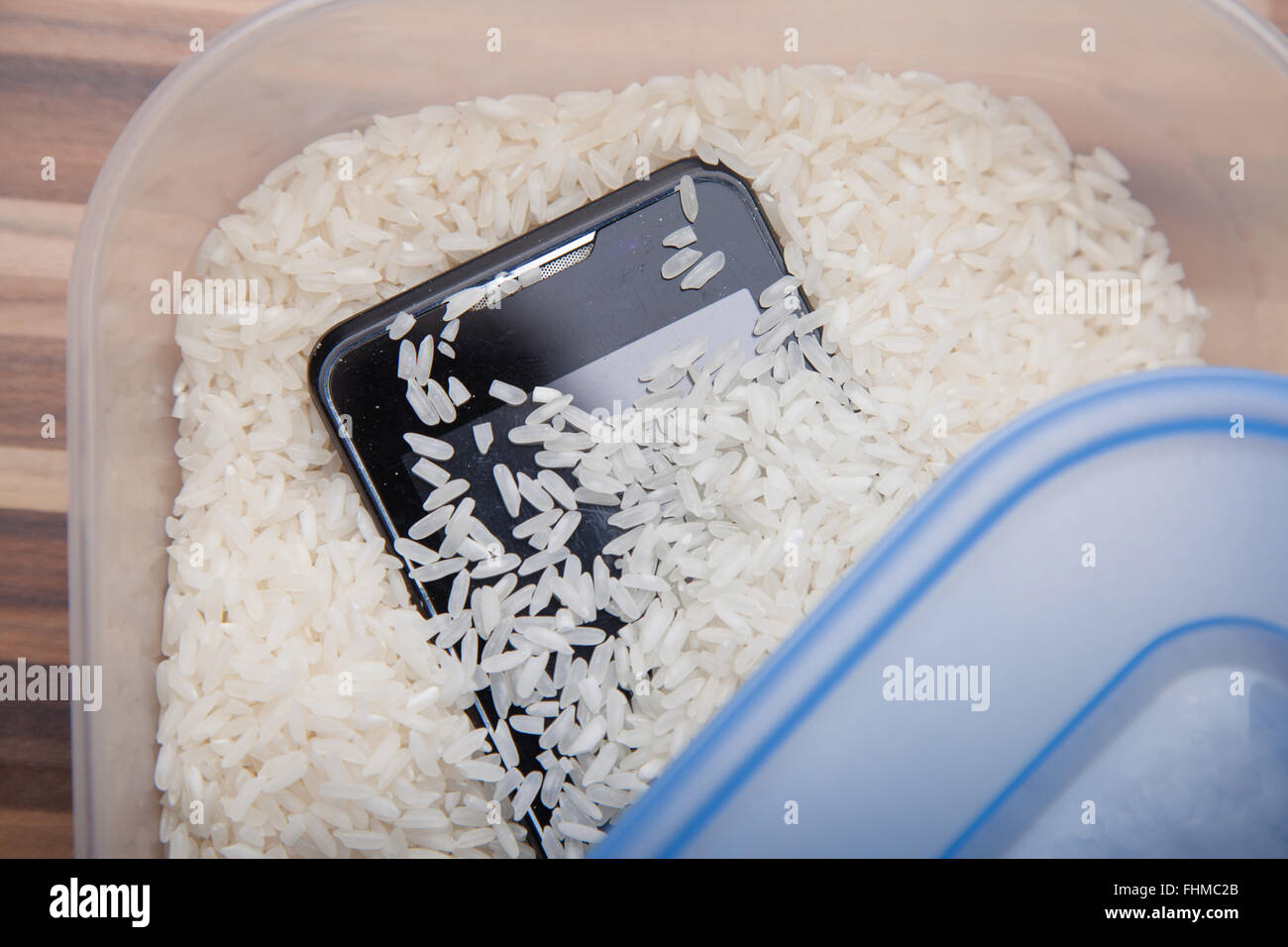 Verwendung von ungekochtem Reis, ziehen Feuchtigkeit von einem Mobiltelefon. Stockfoto