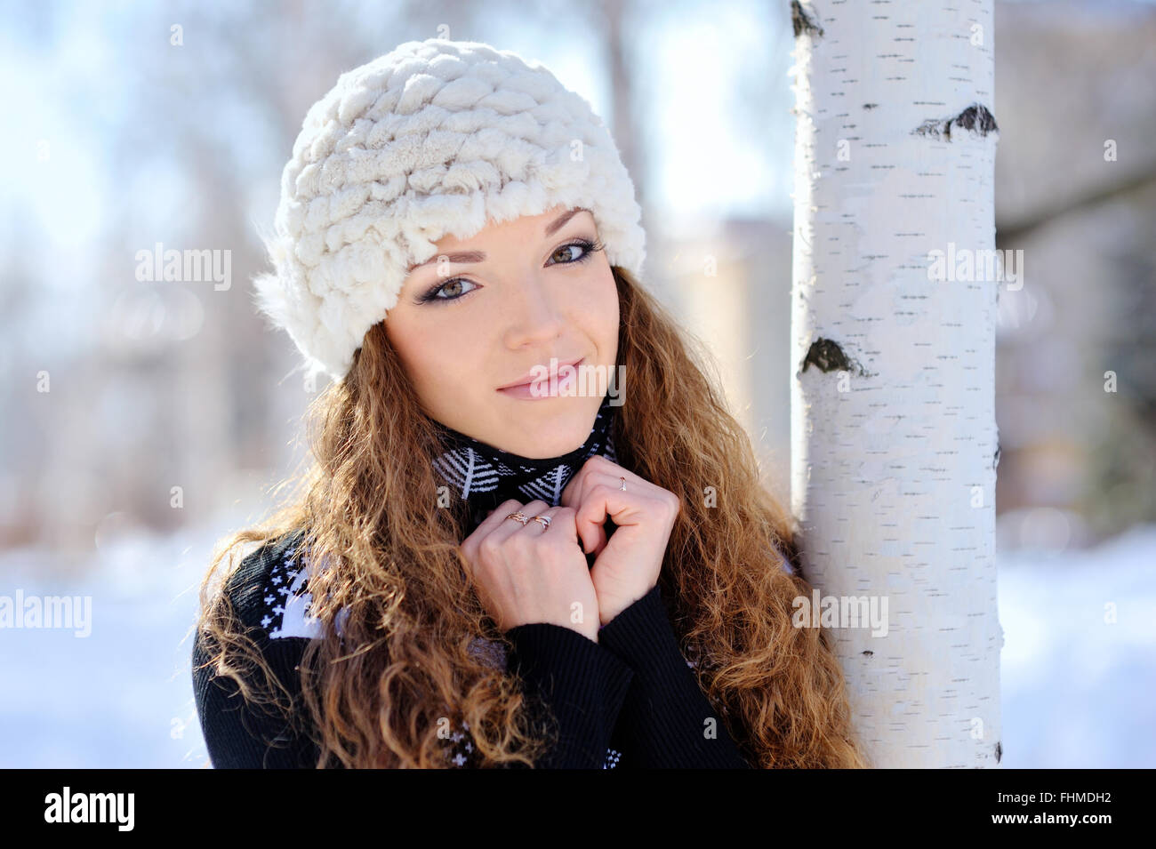 schönes Mädchen steht in der Nähe der Birke im winter Stockfoto