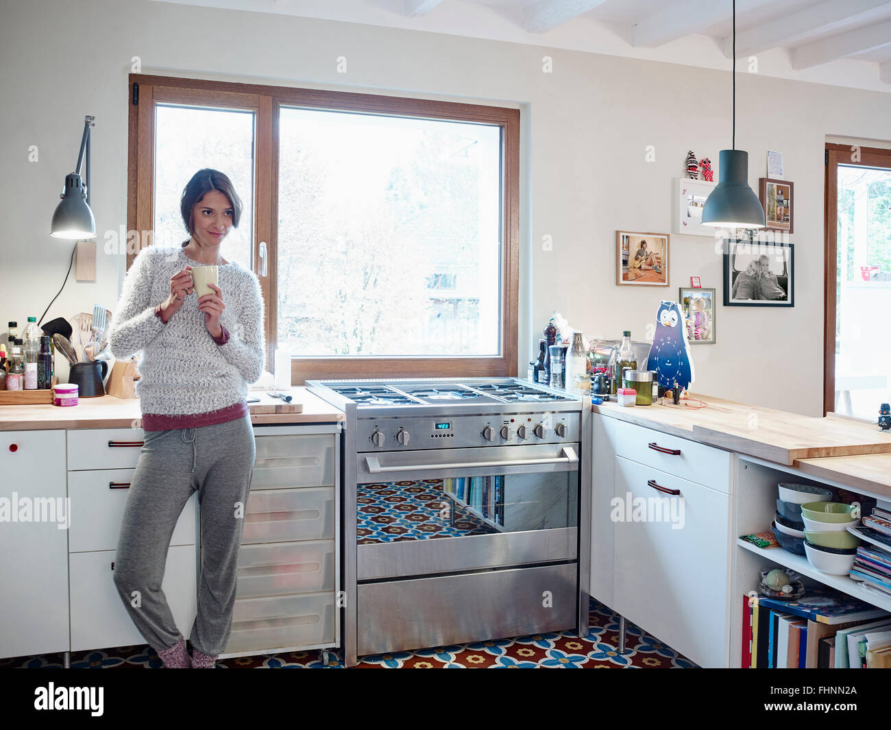 Entspannte Frau hält Cup in Küche Stockfoto