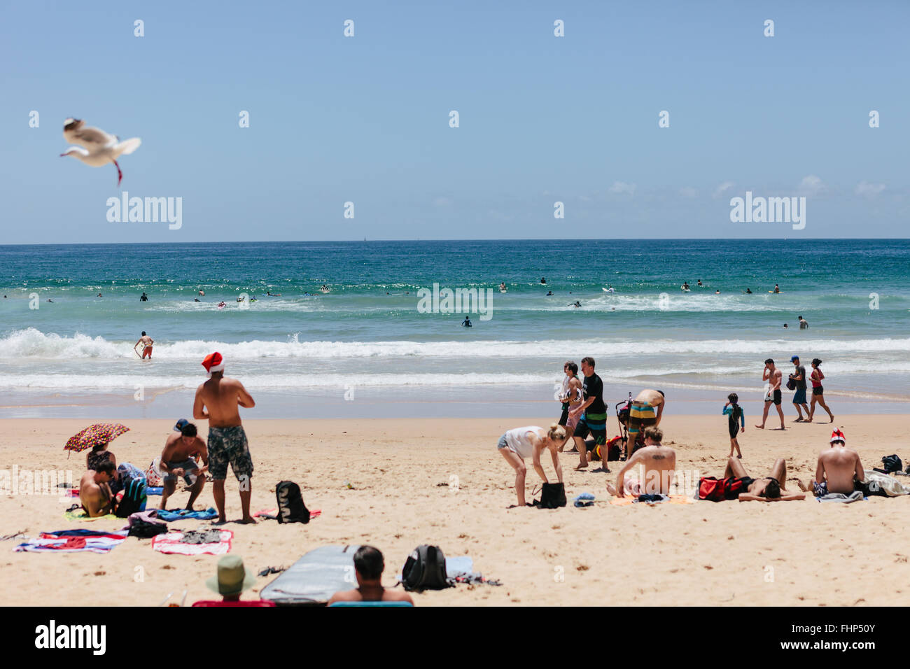 Heiligabend am Manly Beach, Sonnenanbeter mit Santa Hüte. Stockfoto