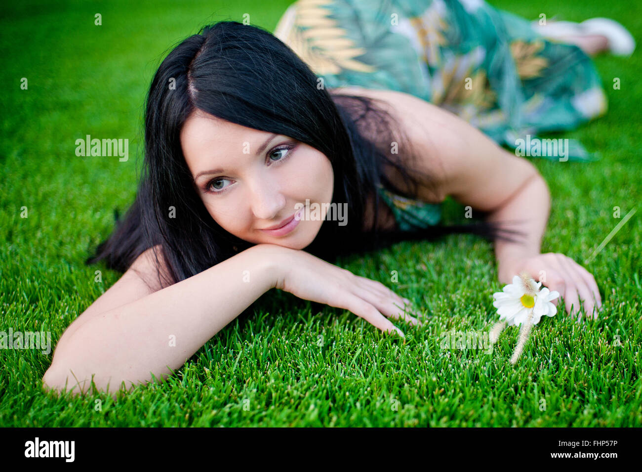schöne Frau liegend auf dem Rasen im Frühjahr Wiese Stockfoto