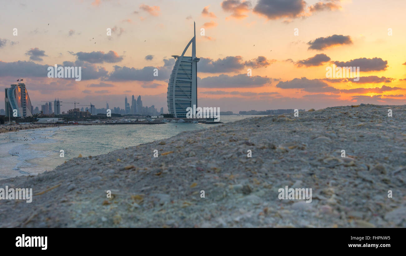 Blick auf die beleuchtete Burj Al Arab und Jumeirah Beach Hotel in den Sonnenuntergang. Blick von der Jumeirah Strand gegenüberliegenden Seite, Dubai. Stockfoto