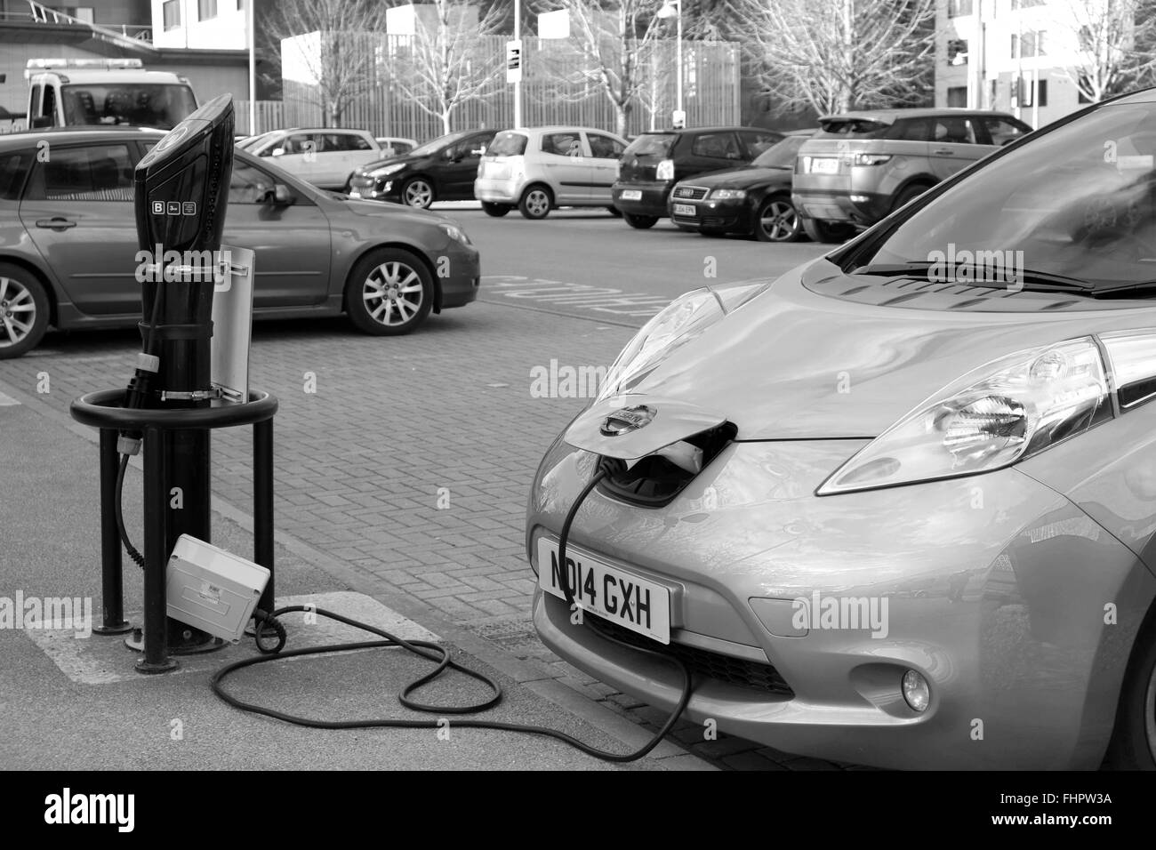 Neue Nissan Leaf Elektroauto angeschlossen und aufgeladen, während auf einem Parkplatz (Parkplatz) Stockfoto