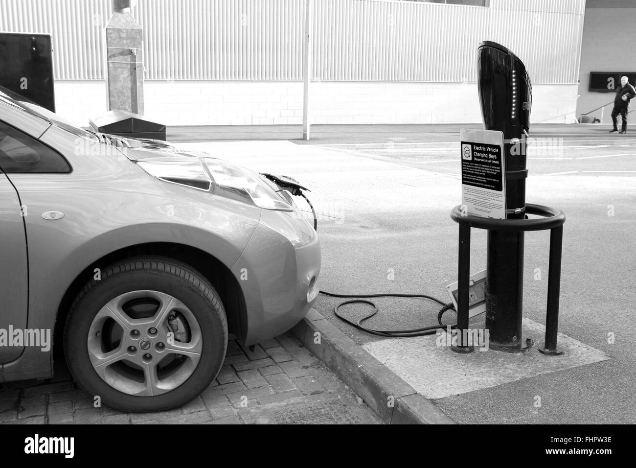 Neue Nissan Leaf Elektroauto angeschlossen und aufgeladen, während auf einem Parkplatz (Parkplatz) Stockfoto