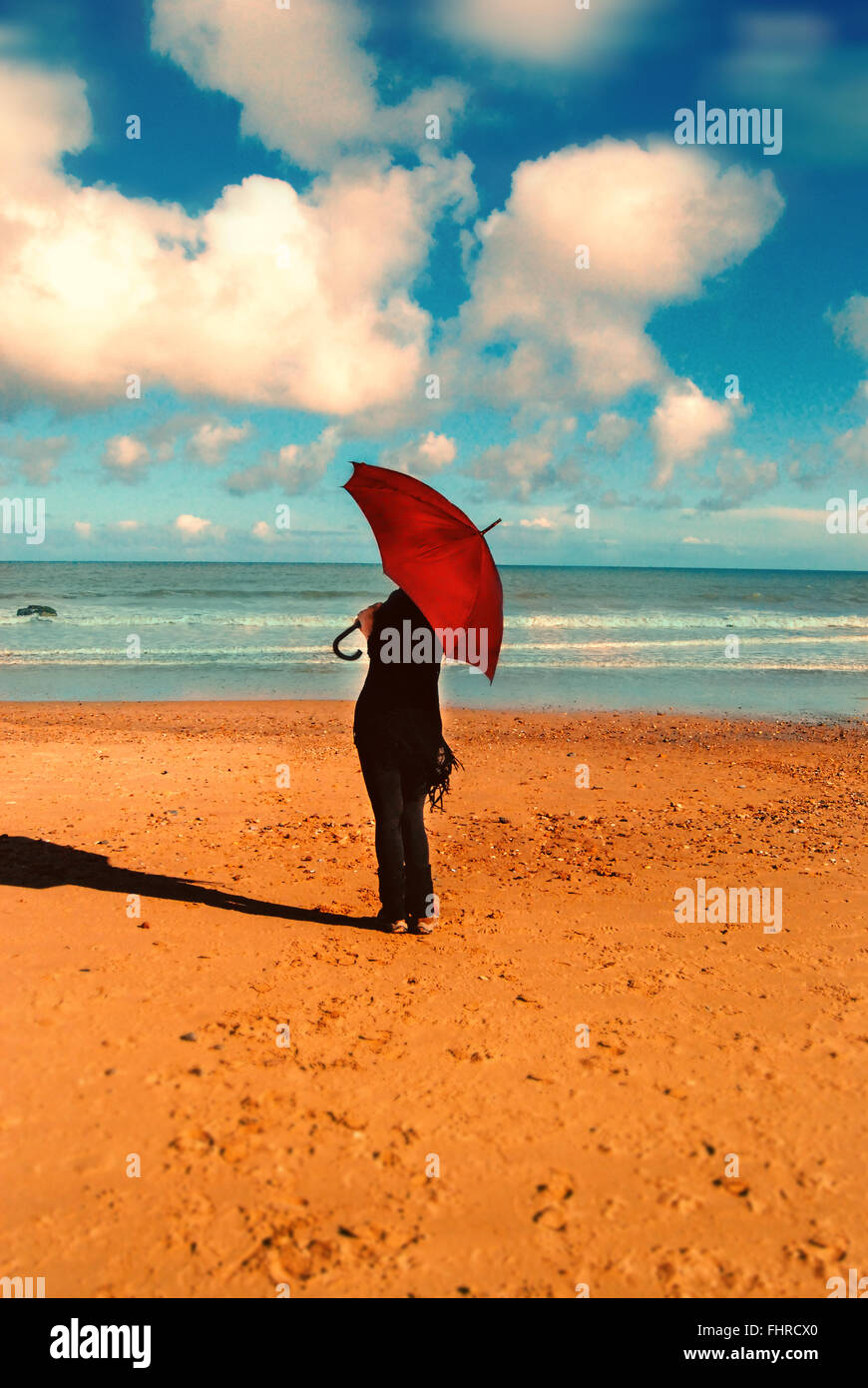 Frau mit roten Regenschirm stehen am Sonnenstrand Stockfoto
