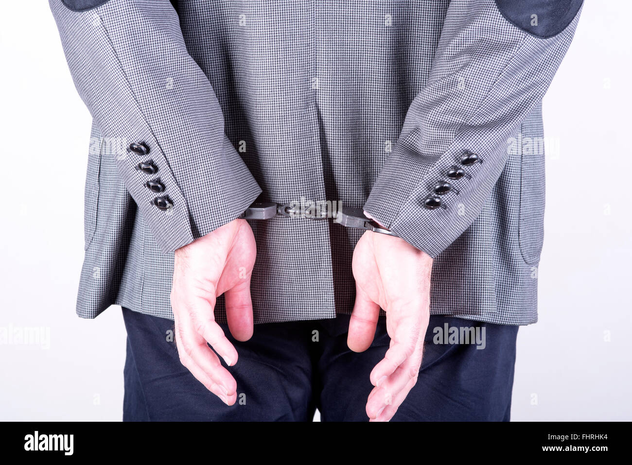ein Bild eines Geschäftsmannes in Handschellen gesperrt Stockfoto