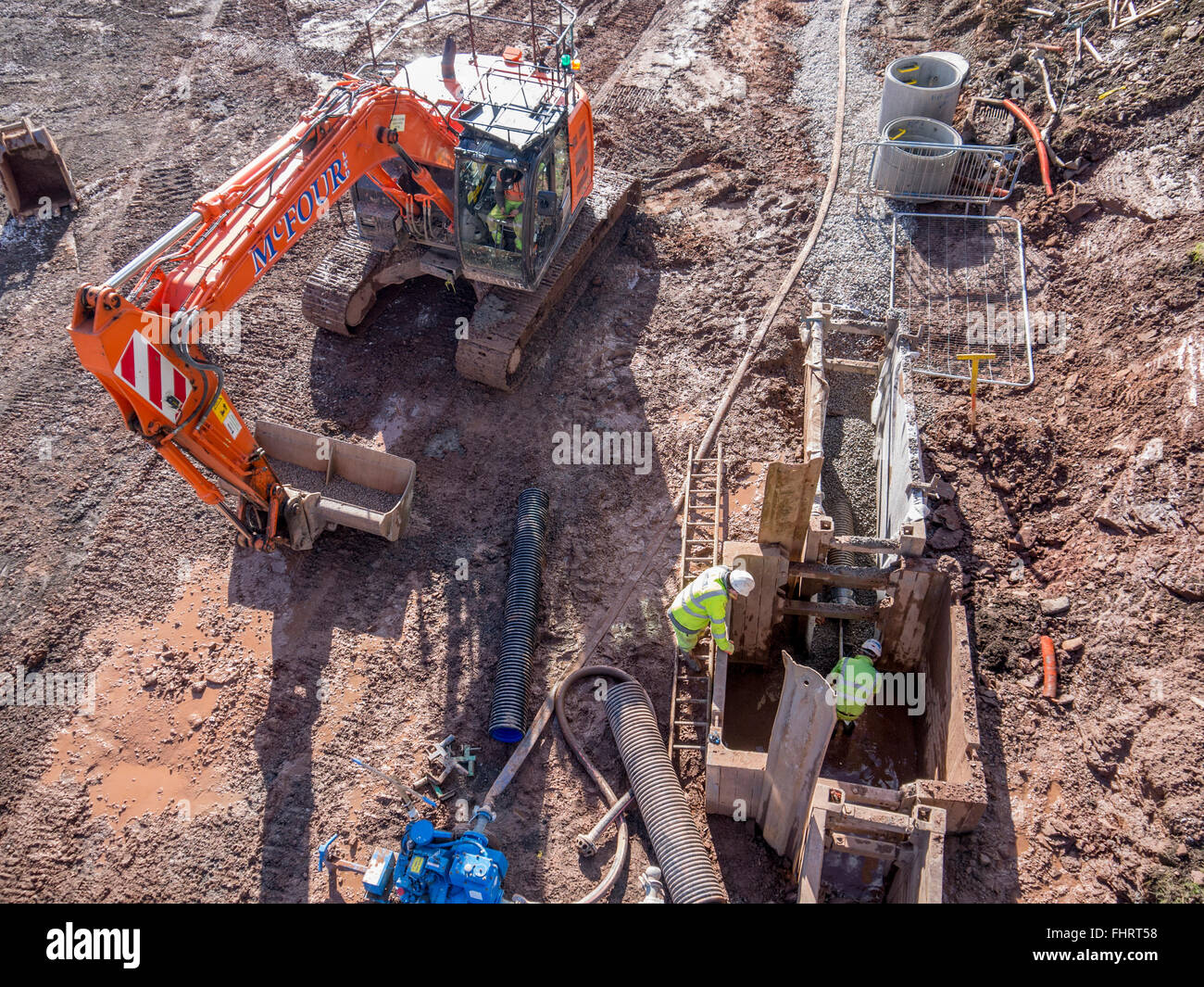 Digger Arbeitnehmer im Baugewerbe ein Loch nach der Verlegung neuer Abwasserleitungen ausfüllen Stockfoto