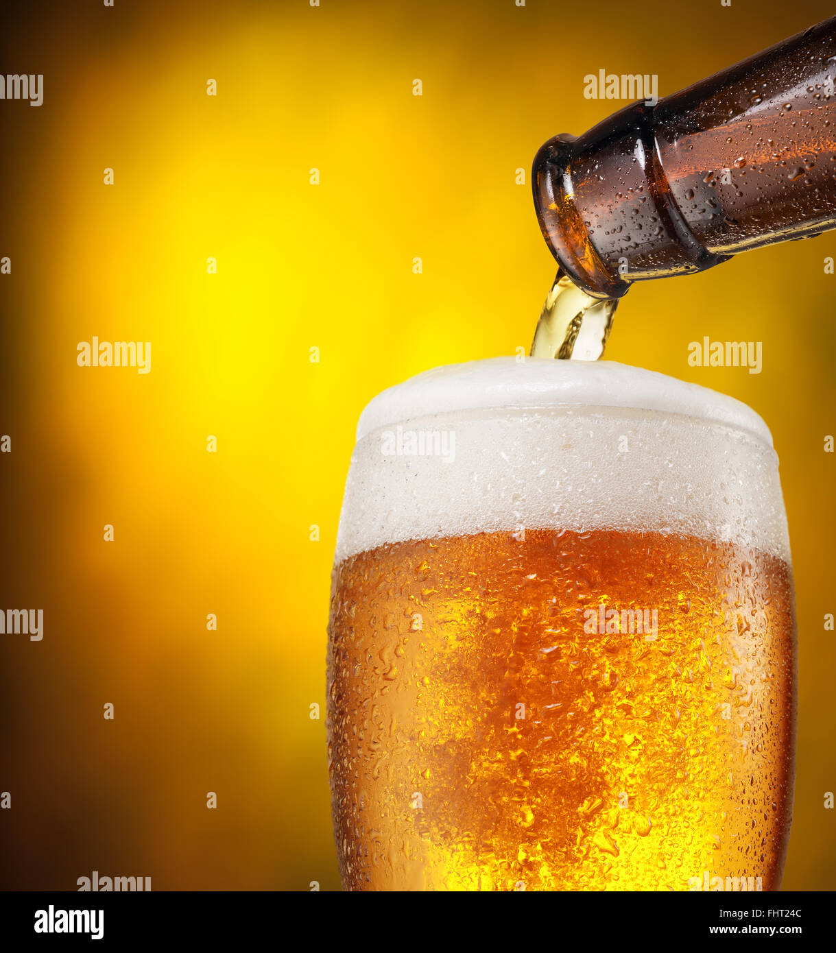 Der Prozess der strömenden Bier in das Glas. Leuchtend orange Hintergrund. Stockfoto