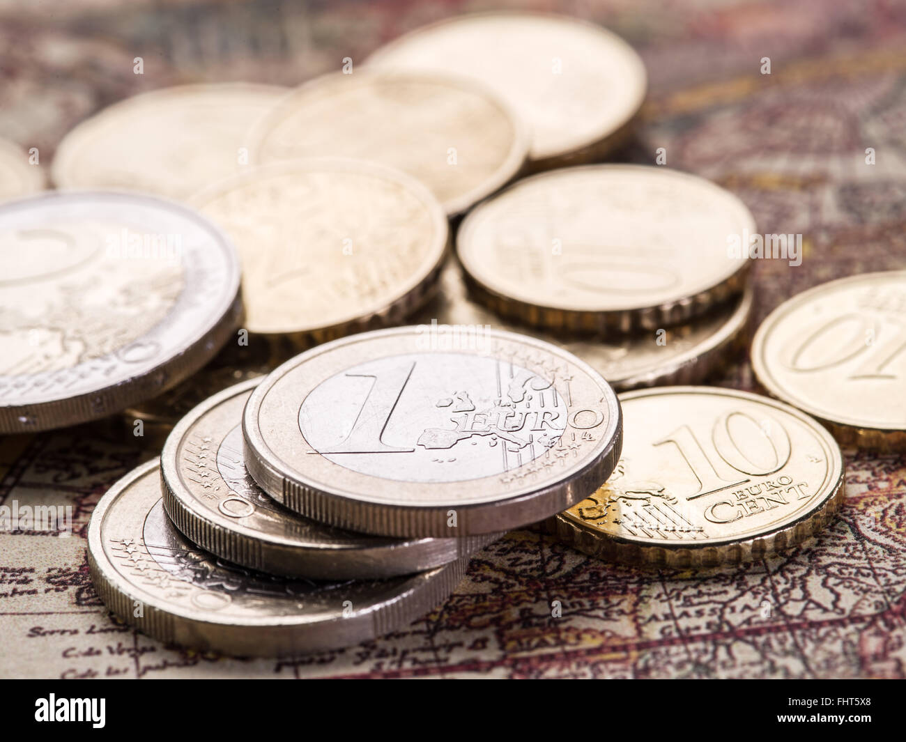Euro-Münzen über die alte Weltkarte. Makro-Bild. Stockfoto