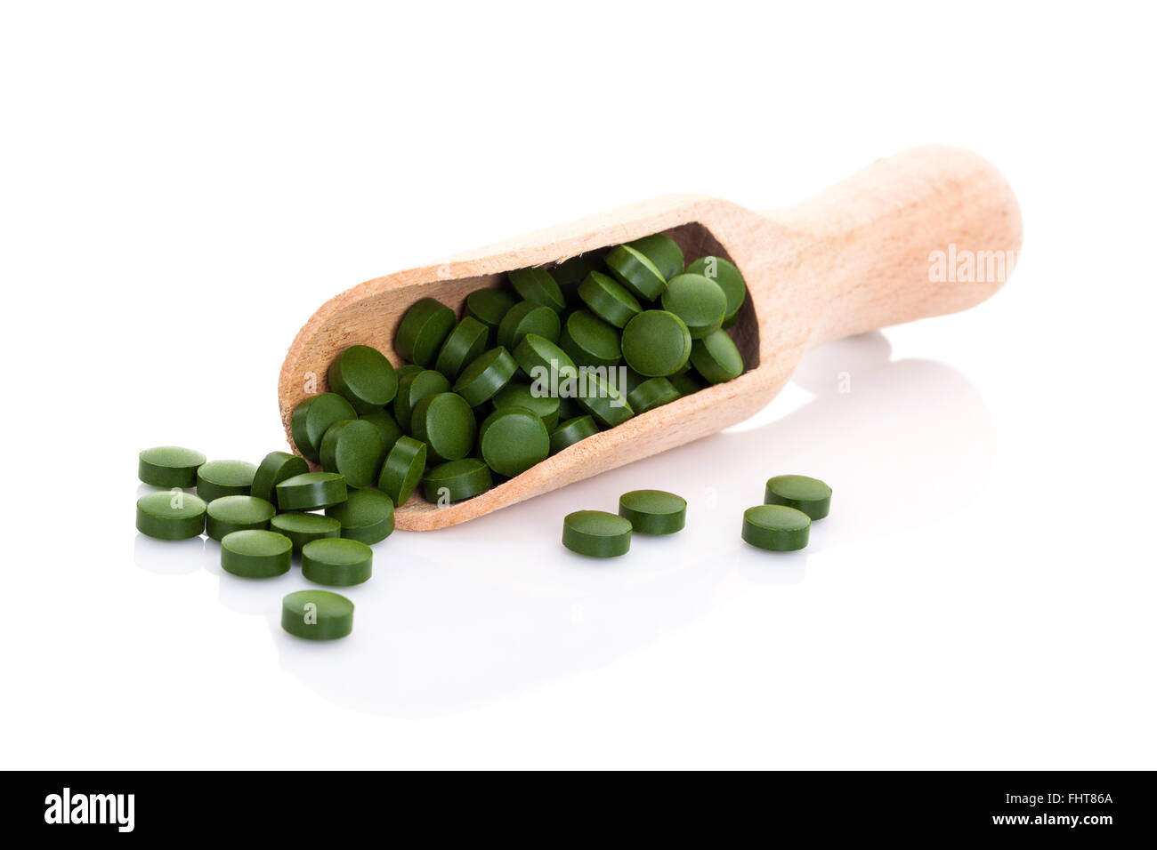 Grüne Pillen auf hölzerne Schaufel. Stockfoto