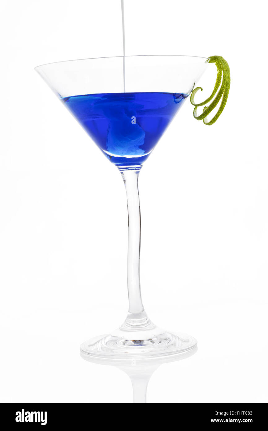 Poring Creme zu einem blauen Cocktail. Stockfoto