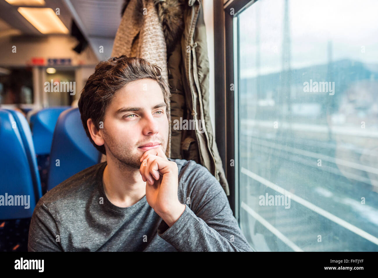 Junger Mann im Zug Auto Blick aus Fenster Stockfoto