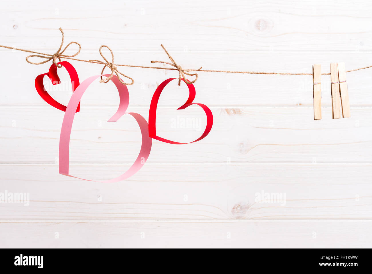 Valentinstag-Konzept, drei Papierherzen am Seil hängend Stockfoto
