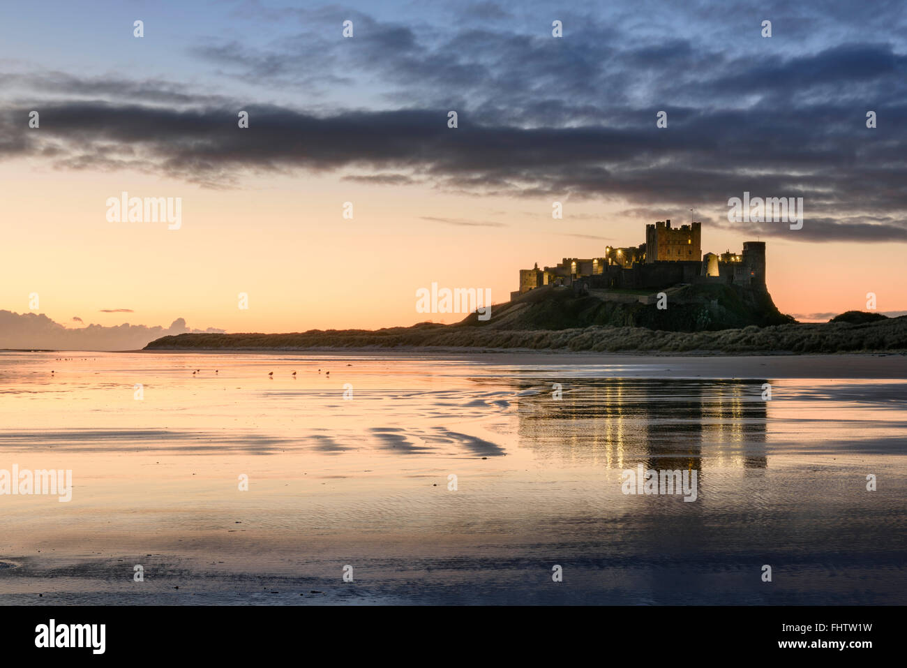 Bamburgh Castle und Strand in Northumberland an der Dämmerung Stockfoto