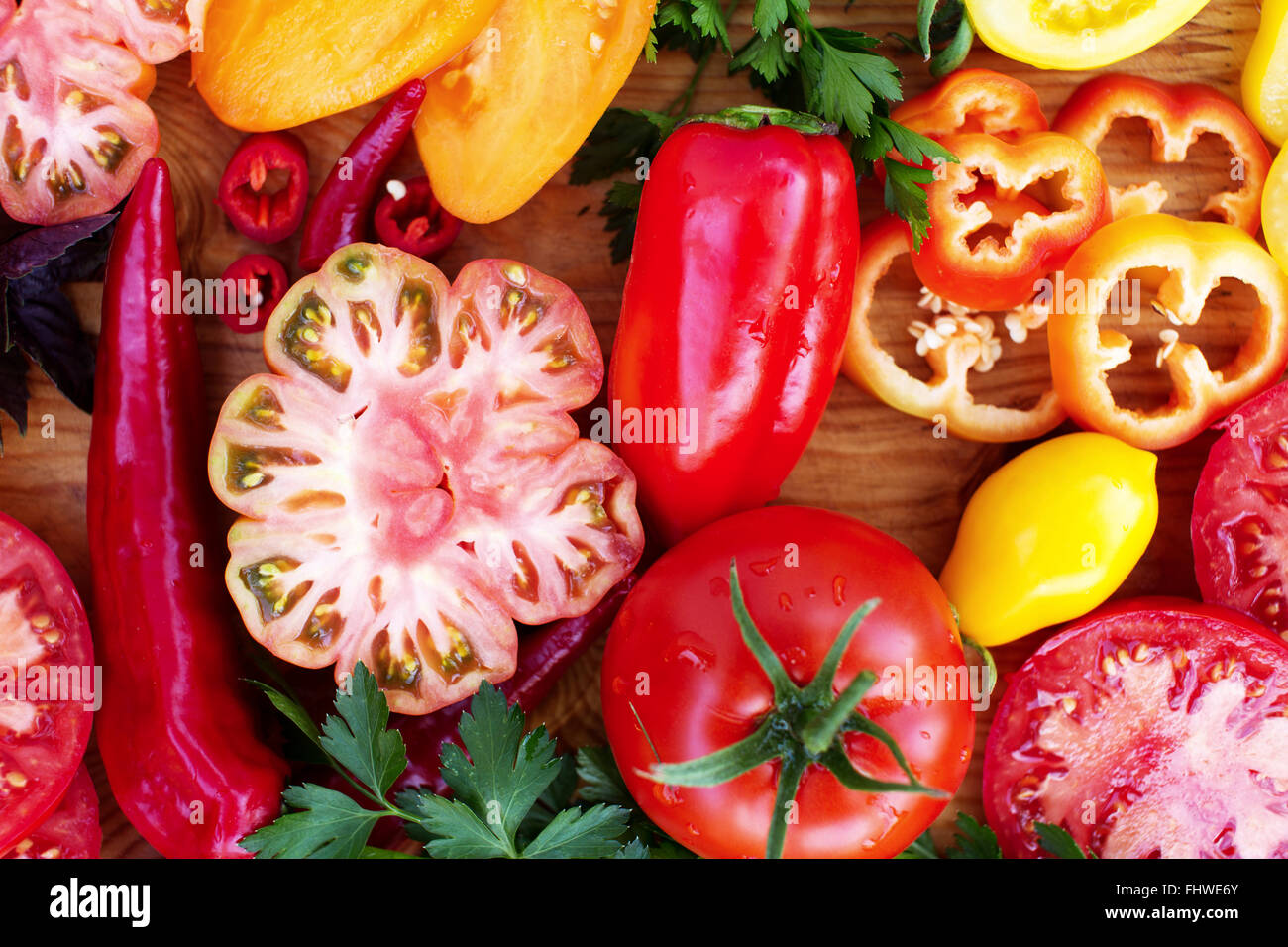 Bunte Bio geschnittene Paprika und Tomaten auf einem Schneidebrett Stockfoto